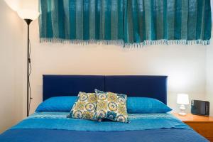 niebieskie łóżko z niebieskim zagłówkiem i dwoma poduszkami w obiekcie The Magic Place w mieście Mazzeo