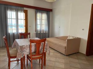 a living room with a table and a couch at Anemos Apartments in Marathokampos