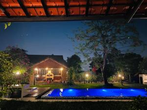 a swimming pool in front of a house at night at La Y Riverview in Hue