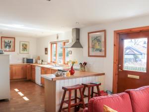 a kitchen with a counter and some stools in it at Brodie East Cottage in Forres