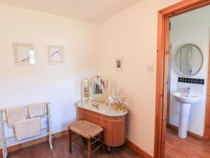 a bathroom with a sink and a mirror at Brodie East Cottage in Forres