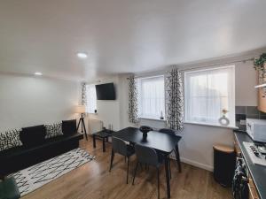 uma cozinha e sala de estar com mesa e cadeiras em FW Haute Apartments at Harwoods Road, Multiple 2 Bedroom Pet-Friendly Flats, King or Twin or Double beds with FREE WIFI and PARKING em Watford