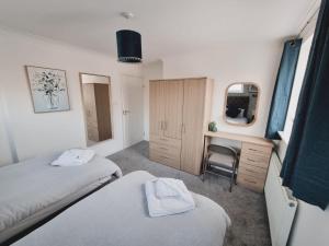 a bedroom with two beds and a desk and a mirror at FW Haute Apartments at Harwoods Road, Multiple 2 Bedroom Pet Friendly Flats, King or Twin or Double beds with FREE WIFI and FREE PARKING in Watford