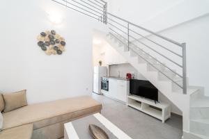 ein Wohnzimmer mit einem Sofa und einer Treppe in der Unterkunft Perla Residential Complex in Ofrynio