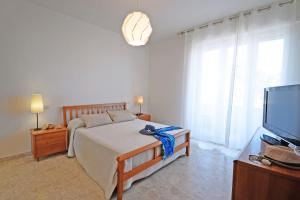 een slaapkamer met een bed en een flatscreen-tv bij Appartamento Bellariva A1 - MyHo Casa in Porto San Giorgio