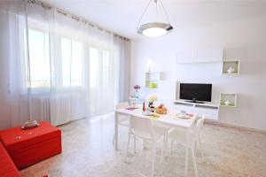 een witte eetkamer met een witte tafel en stoelen bij Appartamento Bellariva A1 - MyHo Casa in Porto San Giorgio