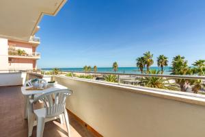 een balkon met een tafel en uitzicht op het strand bij Appartamento Bellariva A1 - MyHo Casa in Porto San Giorgio
