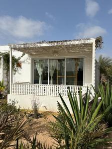 una pequeña casa blanca con una valla blanca en Útulný apartmán na Praia de Chaves, Boa Vista en Sal Rei