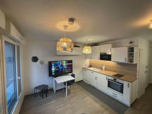 a kitchen with a table and a desk with a computer at Studio Design & Cosy avec Parking in Issy-les-Moulineaux