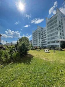 a large building with a grass field in front of it at Studio Design & Cosy avec Parking in Issy-les-Moulineaux