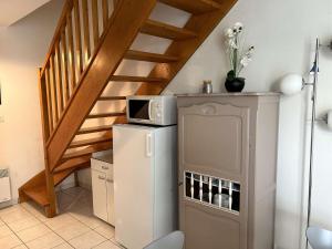 d'un petit réfrigérateur dans une cuisine avec un escalier. dans l'établissement Maison Bretignolles-sur-Mer, 4 pièces, 6 personnes - FR-1-224A-26, à Bretignolles-sur-Mer