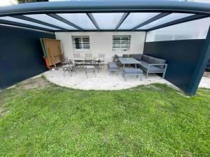 a patio with a table and chairs in the grass at Appartement 2 pièces cozy au calme in Mitry-Mory