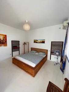 ein Schlafzimmer mit einem Holzbett in einem Zimmer in der Unterkunft Útulný apartmán na Praia de Chaves, Boa Vista in Sal Rei
