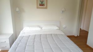 uma grande cama branca num quarto branco em CASALE SUL CLITUNNO em Foligno