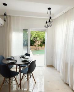 Kallikratis Apartment Near Athens Airport في سباتا: غرفة طعام مع طاولة وكراسي