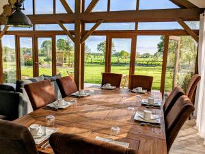 a large wooden table in a room with a large window at Chambres d'hôtes chez l'habitant - Bed & Breakfast homestay in Huisnes-sur-Mer