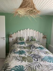 um quarto com uma cama grande e uma cabeceira em madeira em Chambre d’hôtes coconing em Brélès