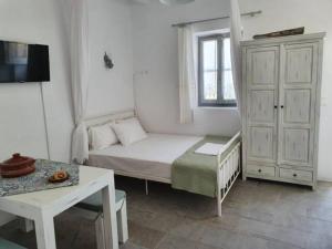 Habitación blanca pequeña con cama y ventana en Merope seaside house, en Platis Yialos Sifnos