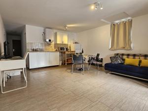 sala de estar con sofá azul y cocina en Apartments ANTONIA - S. Novalja, en Stara Novalja