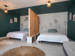 Au Doubs Tallans : سريرين في غرفة بجدران خضراء