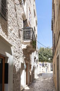 um beco com uma varanda do lado de um edifício em Stanley Helenski - apartment in old town em Šibenik