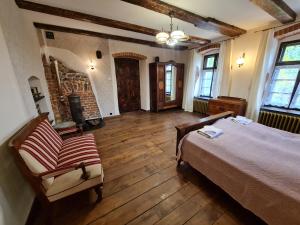 a bedroom with a bed and a chair and a fireplace at Czerwony Dworek 8 - Agroturystyka Karkonosze in Mysłakowice