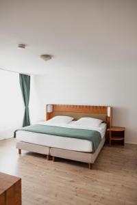 a bedroom with a bed with a wooden headboard at Hotel Cristallo in Landshut