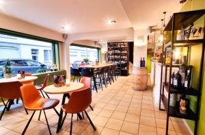 a restaurant with tables and chairs and a bar at Hotel De Golf in Bredene