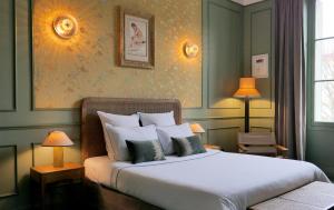 a bedroom with a large white bed with two lamps at H&ocirc;tel Bristol Pau in Pau