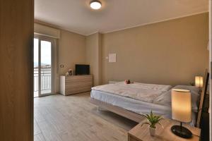1 dormitorio con 1 cama grande y balcón en Appartamento Stella -Rebomaholidays, en Olzano