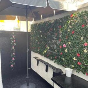 ブラックプールにあるThe Butterfly Hotelの花の茂みの前に傘をさすテーブル