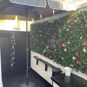ブラックプールにあるThe Butterfly Hotel Group Weekendsの花の茂みの前に傘をさすテーブル
