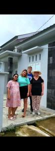 a group of people standing in front of a house at HomeStay Pandan Baru in Halangan