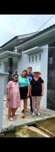 a group of people standing in front of a house at Alceo Homestay Pandan in Halangan