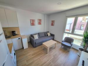 a living room with a couch and a table at Apartamento a estrenar en Planta Primera C con piscina in Barbate