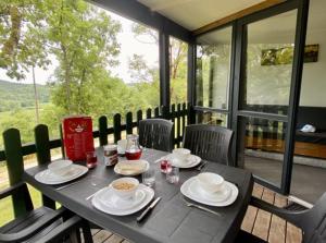 een zwarte tafel met borden en kommen met eten erop bij Camping Paradis Le Céou in Saint-Cybranet