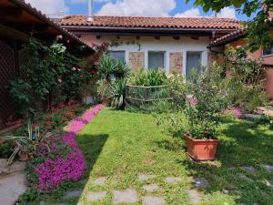 einen Garten mit rosa Blumen vor einem Haus in der Unterkunft Holydays Home LITTLE FROG in Agliano Terme