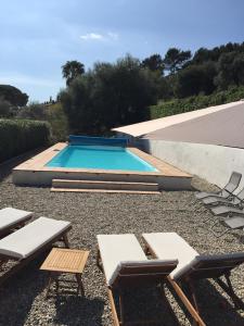 uma piscina com espreguiçadeiras e uma mesa e sidx sidx em Mas Chamarel, la Provence entre vignes et oliviers proche de la mer em Sanary-sur-Mer