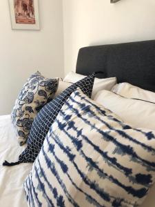 ein Bett mit einer blauen und weißen Decke und Kissen in der Unterkunft A Beira Do Vale, Carvoeiro in Carvoeiro