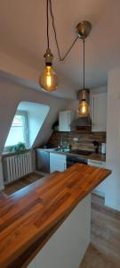 a kitchen with a wooden counter top and two lights at AlleeSuite, Nähe Messe, RÜ, Baldeneysee, Zentral, NETFLIX in Essen