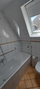 a bathroom with a tub and a toilet and a window at AlleeSuite, Nähe Messe, RÜ, Baldeneysee, Zentral, NETFLIX in Essen