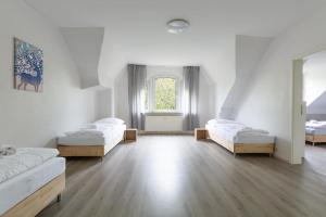 pokój z 3 łóżkami i oknem w obiekcie T&K Apartments Duisburg 4 Apartments 110qm with balcony w mieście Duisburg