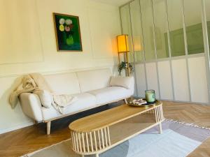 - un salon avec un canapé blanc et une table basse dans l'établissement Appartement Chèvremont Metz, à Metz