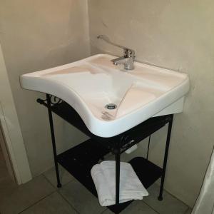 a white sink in a bathroom with towels under it at La Casaregina in Valdieri