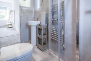 La salle de bains est pourvue de toilettes et d'un lavabo. dans l'établissement Canol Y Bryn - 3 Bedroom Holiday Home - Tenby, à Tenby