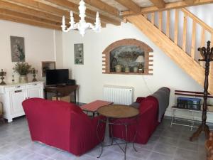 ein Wohnzimmer mit einem roten Sofa und einem Tisch in der Unterkunft Barbazan comminges in Barbazan