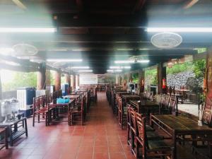 um restaurante vazio com mesas e cadeiras de madeira em Sun Villa & Resort Hòa Bình - 6 em Hòa Bình