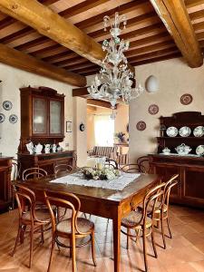 a dining room with a table with chairs and a chandelier at La Bargnina in Serrungarina