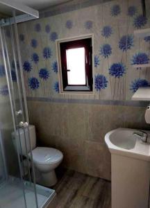 bagno con servizi igienici, lavandino e finestra di u Kapitana a Rowy