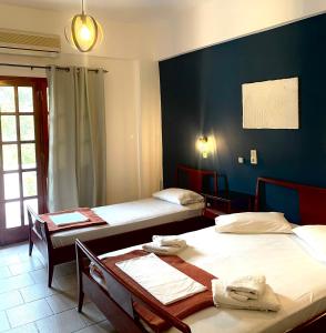 Cette chambre comprend deux lits et une table avec des chaises. dans l'établissement Venetia, à Tsoútsouros